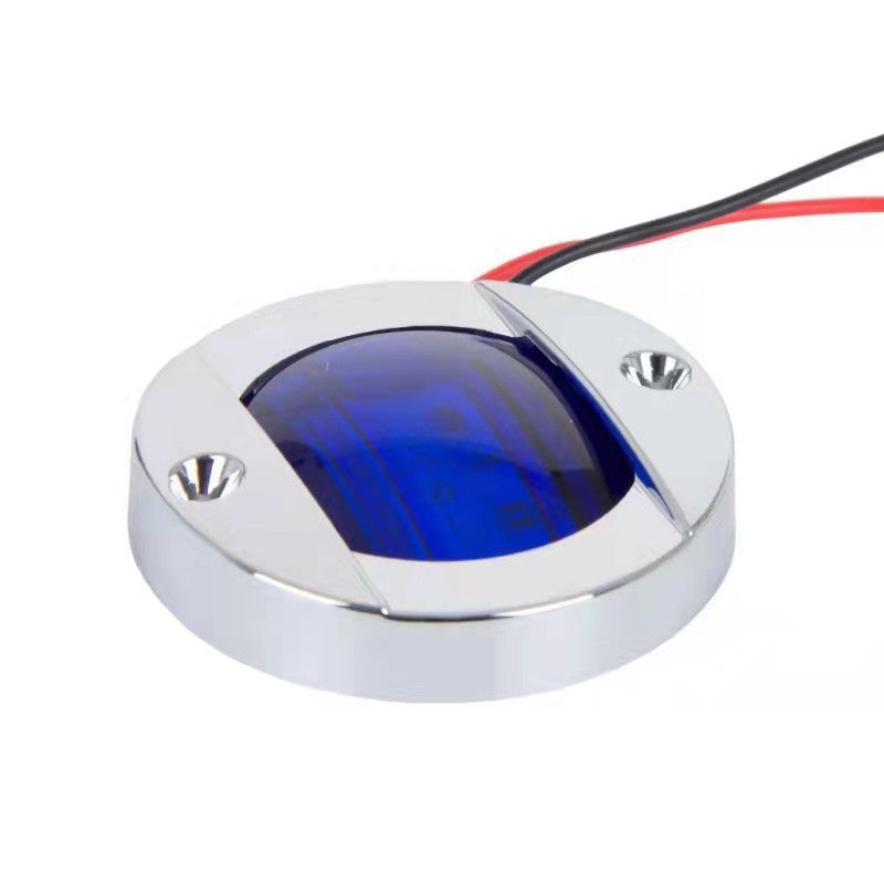 Round metallic light with blue glass cover and wiring on a white background