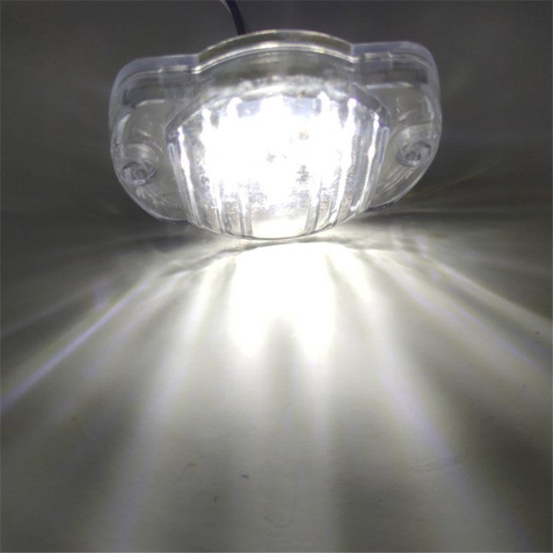Clear LED light bulb on a reflective surface with a dark background